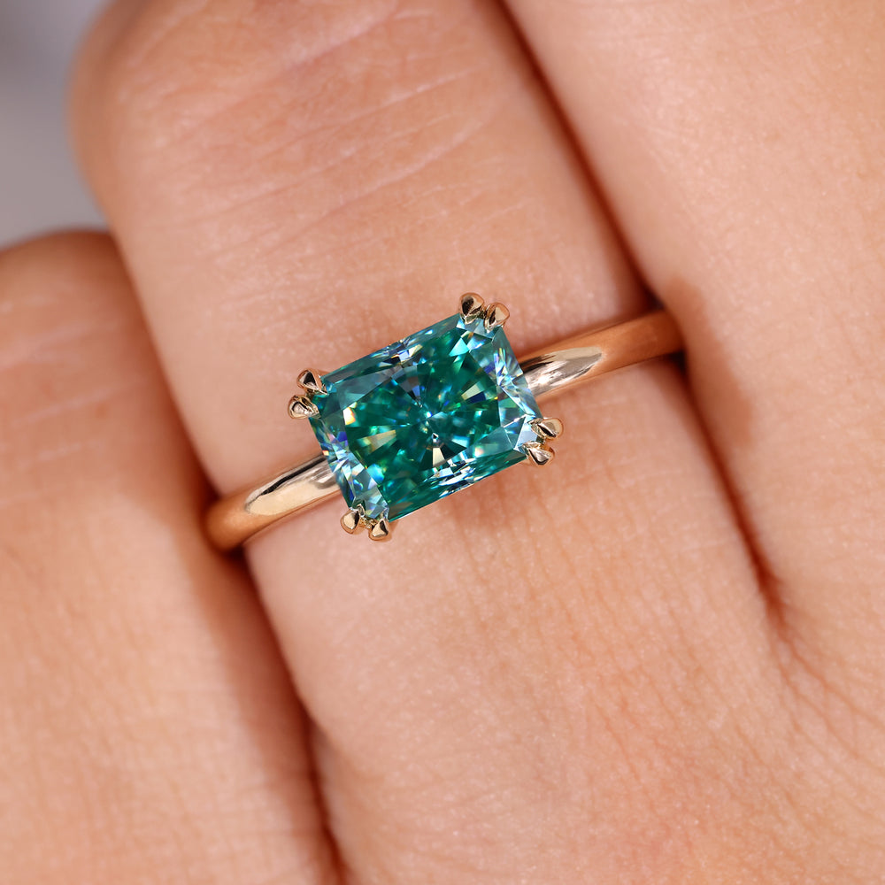 East west moissanite ring in a solitaire yellow gold style.