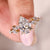 Pear diamond ring with a marquise and round side diamond layout in yellow gold.
