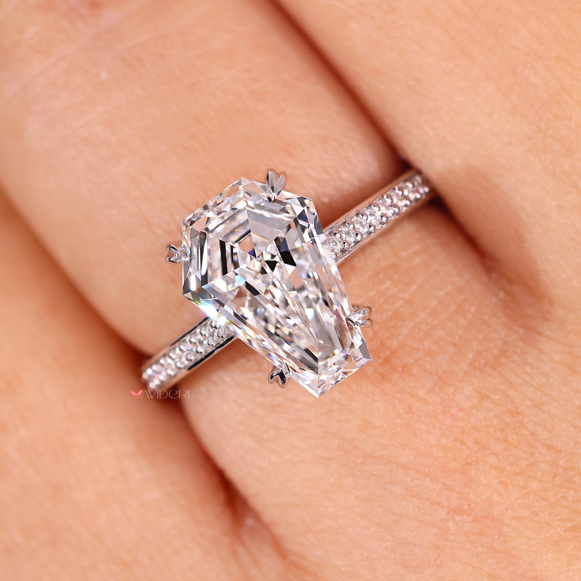 White gold ring with a coffin cut diamond and heart setting.