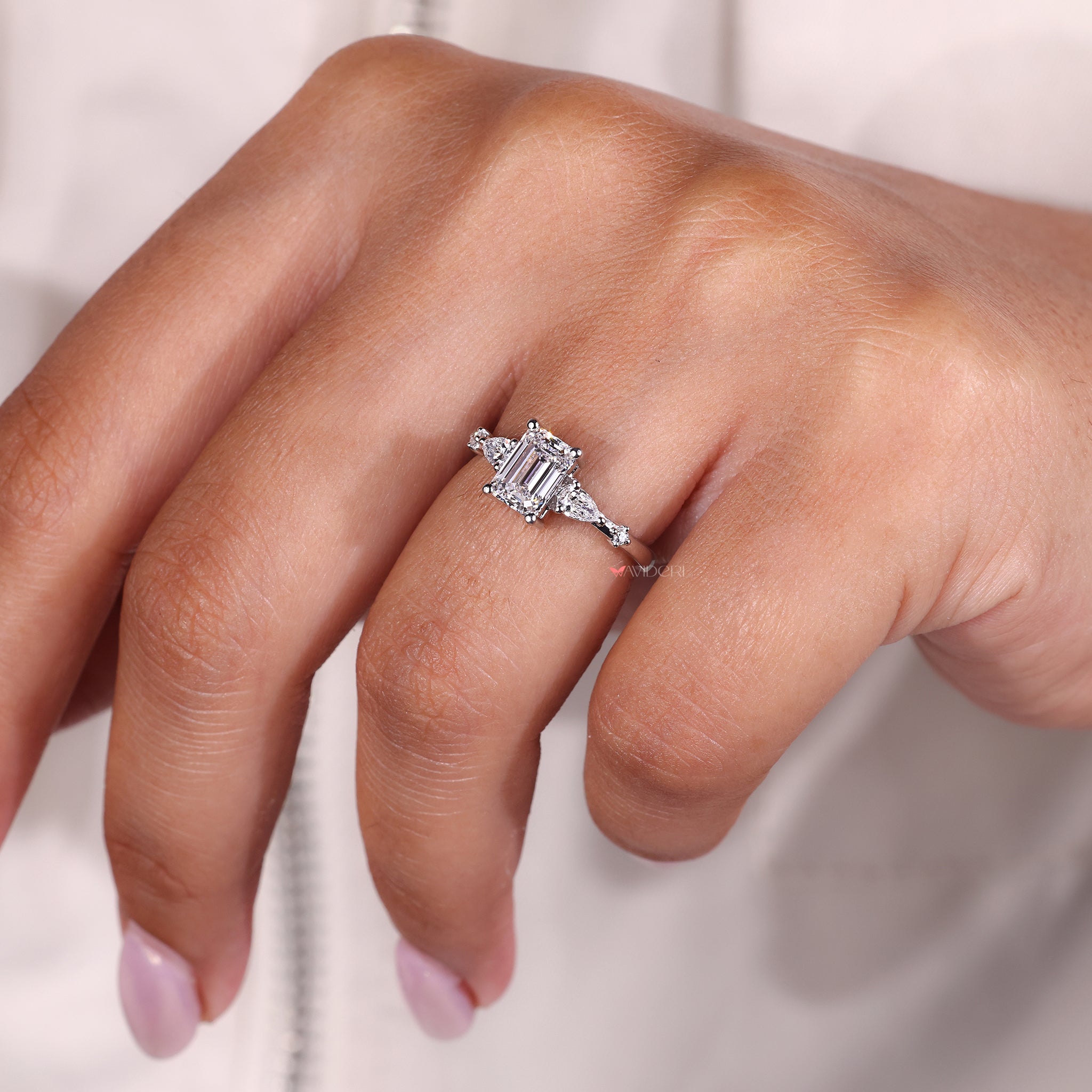 Custom Engagement Ring from Avideri ring with emerald center and five stone diamond layout.
