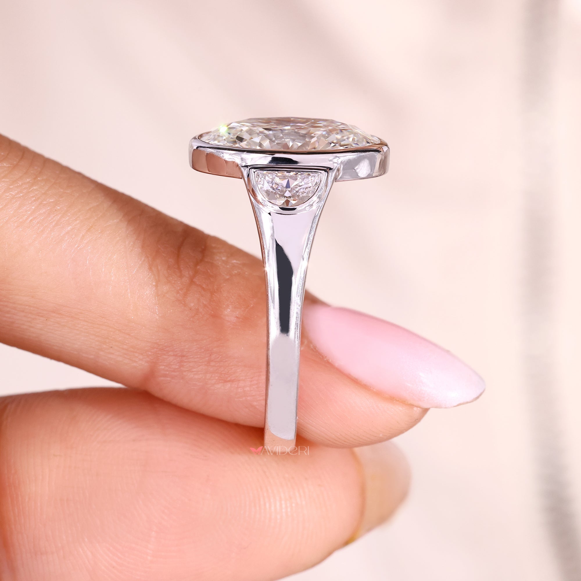 White gold three stone engagement ring in bezel setting.