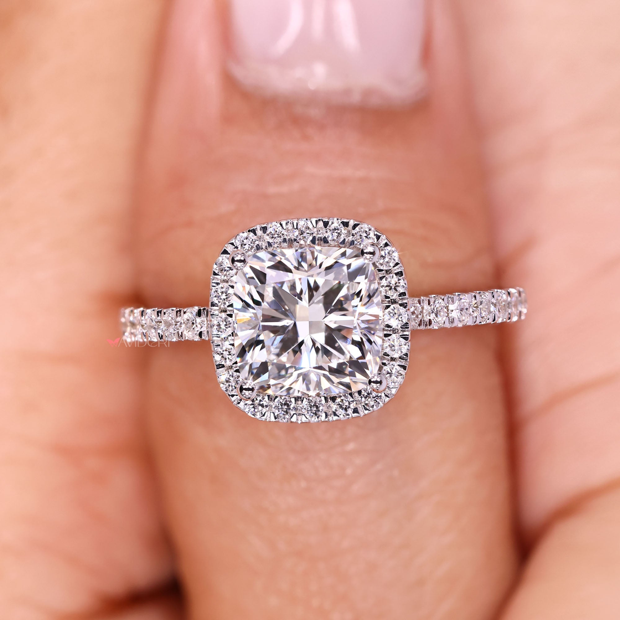 Elegant cushion cut diamond ring with halo detail.
