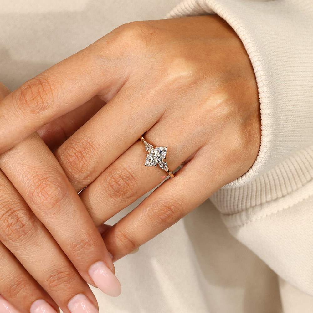 Marquise diamond ring with kite cut side stone.
