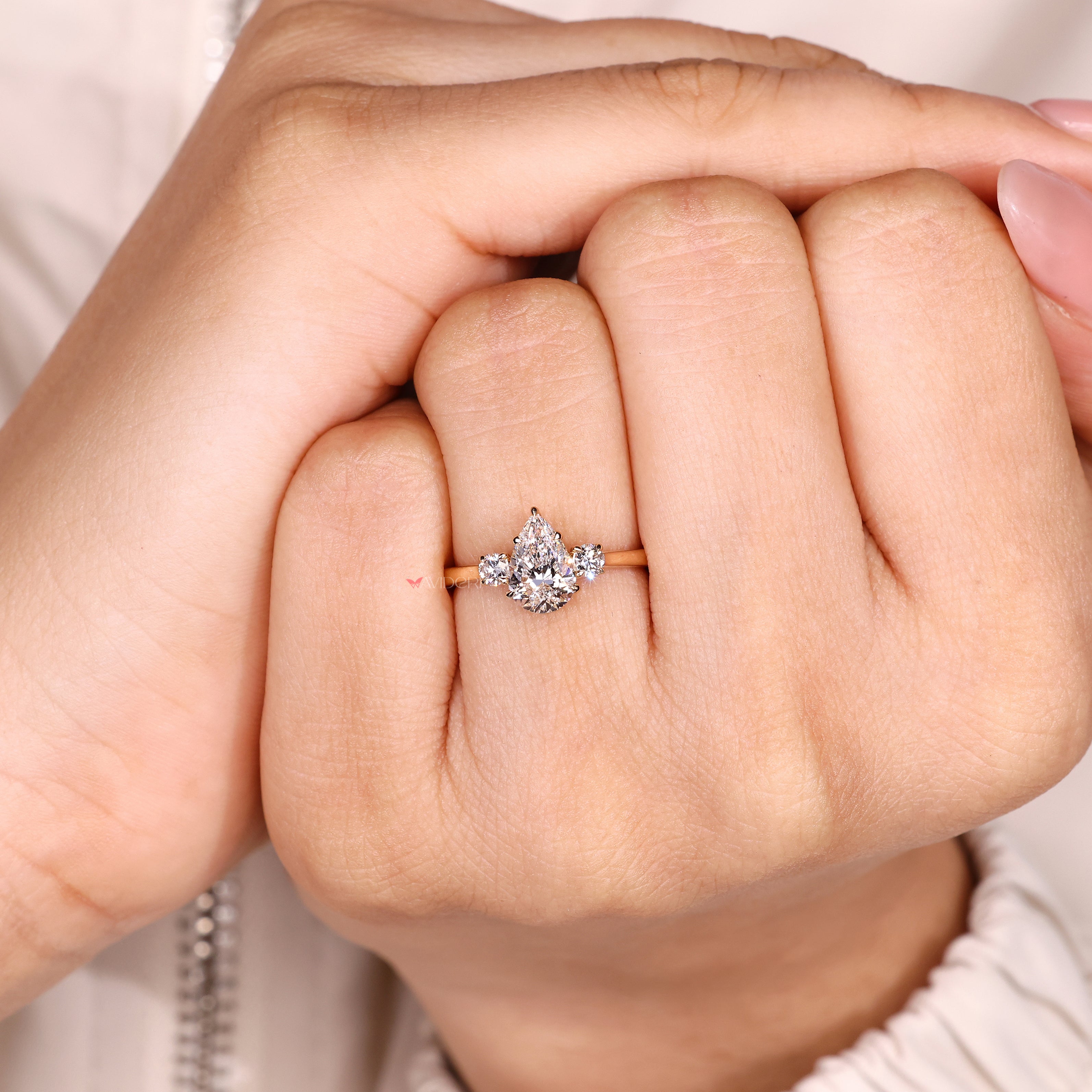 Pear cut three stone ring with round accent diamonds

