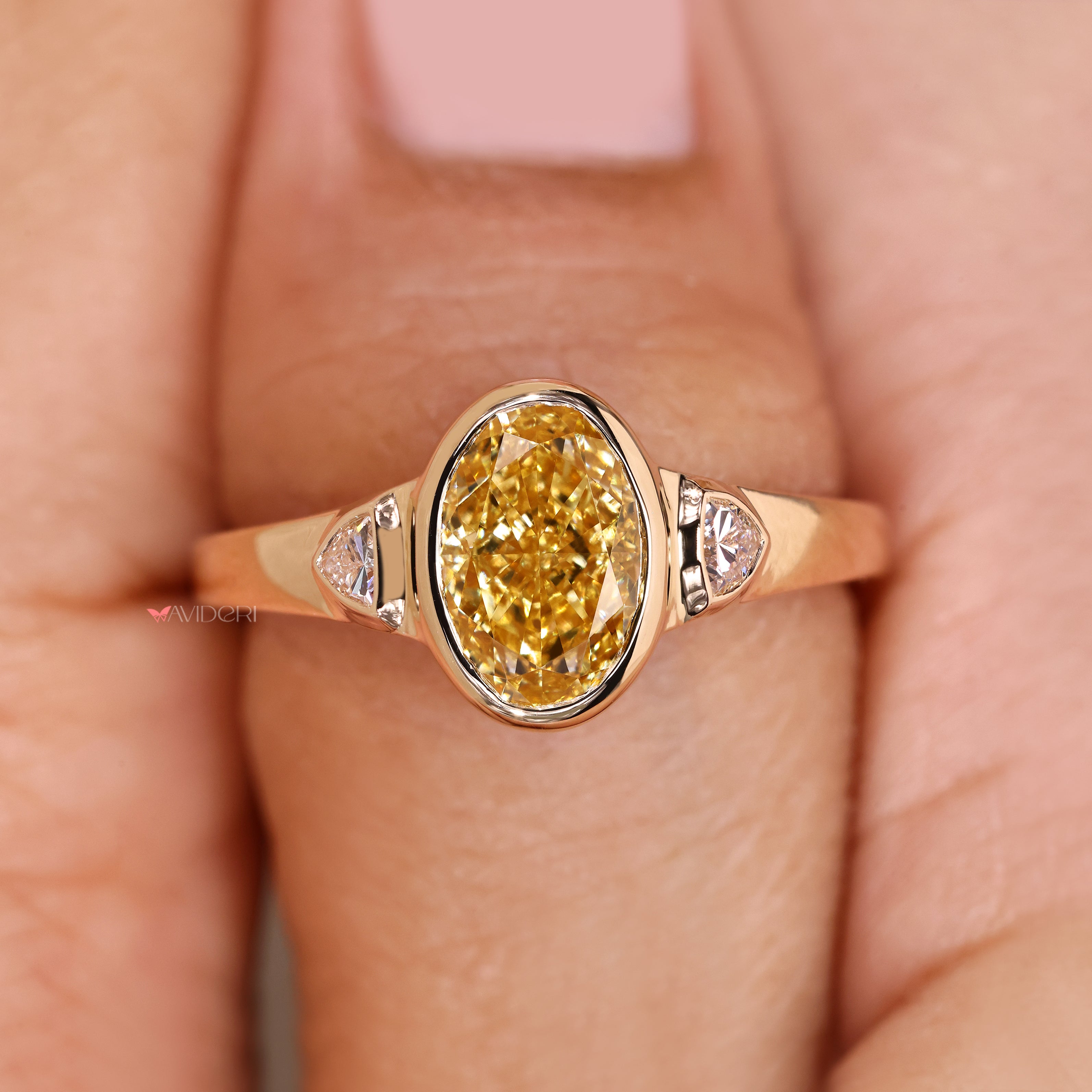 Oval cut ring with yellow diamond and sides.
