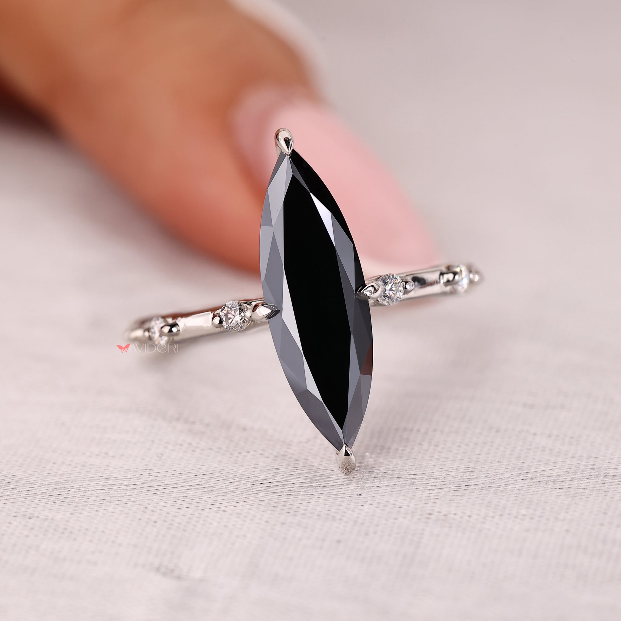 Moissanite engagement ring with a marquise cut centerpiece.