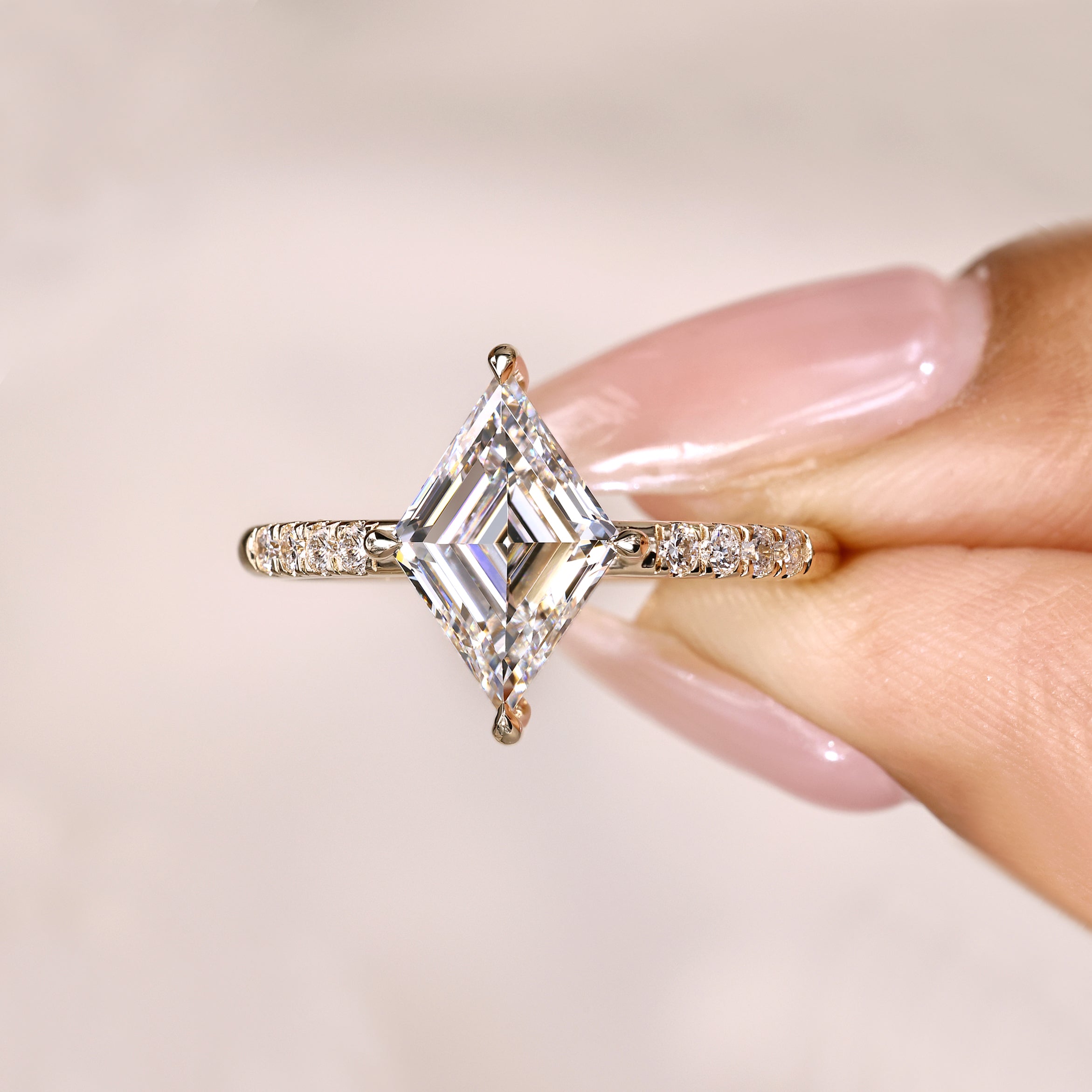 Lozenge diamond ring with round pave setting.
