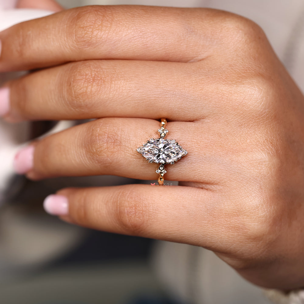Marquise cut diamond ring with cluster setting.