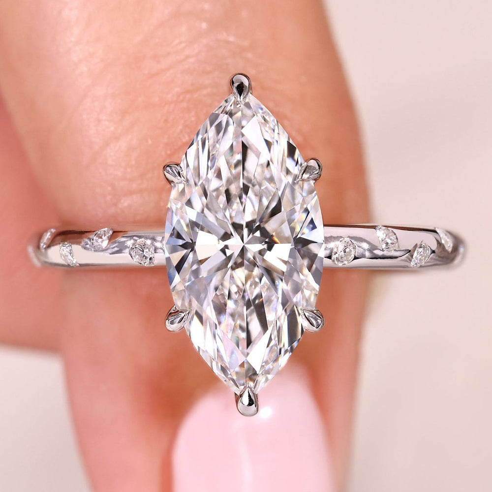 Marquise cut diamond ring with flush pave band.
