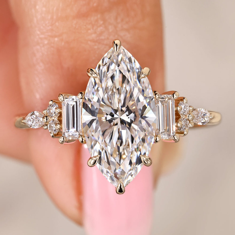 Marquise diamond engagement ring with mixed side stones.
