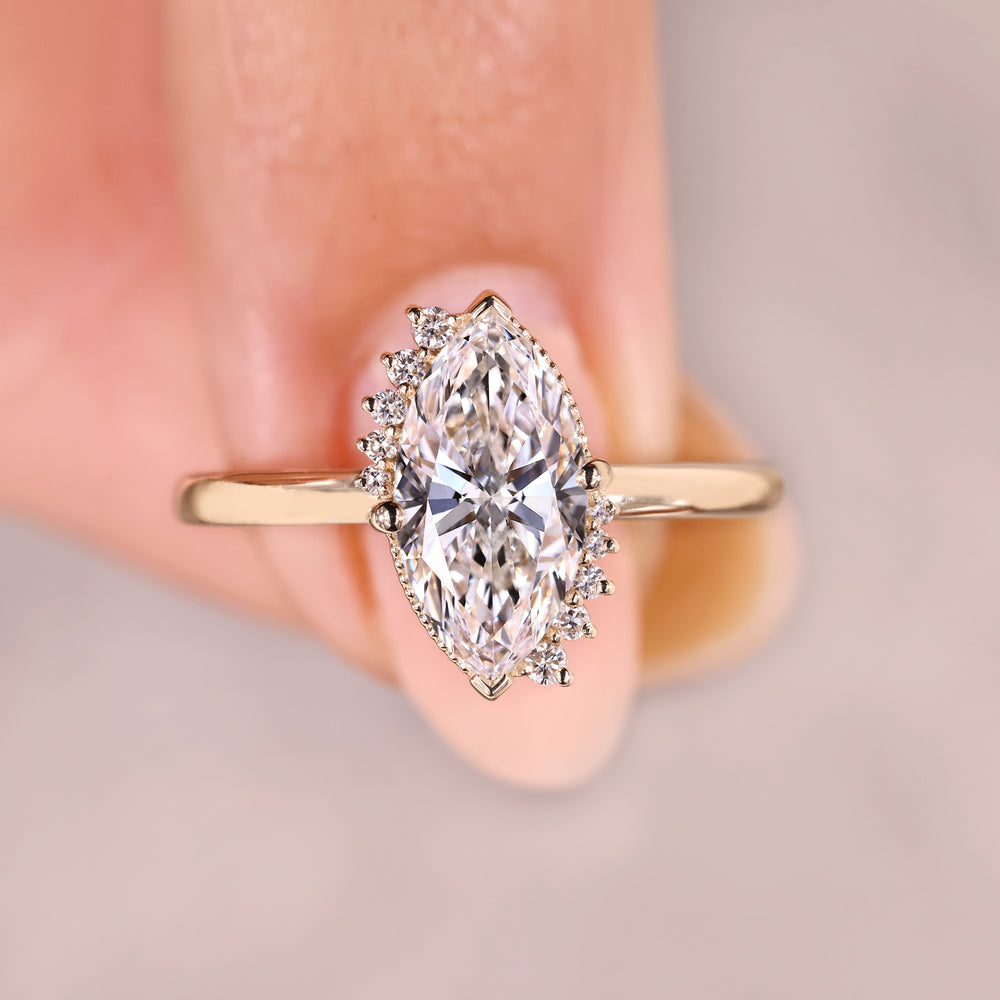 Marquise diamond ring with round side stones.
