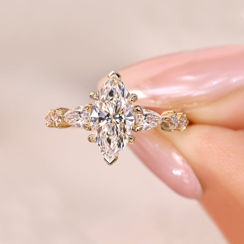 Marquise ring with pear and round diamond pave.
