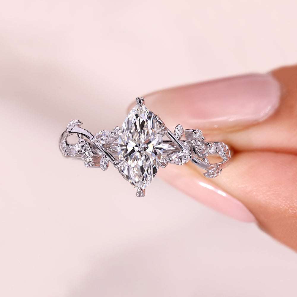 Marquise diamond ring with leaf prong and side stones.
