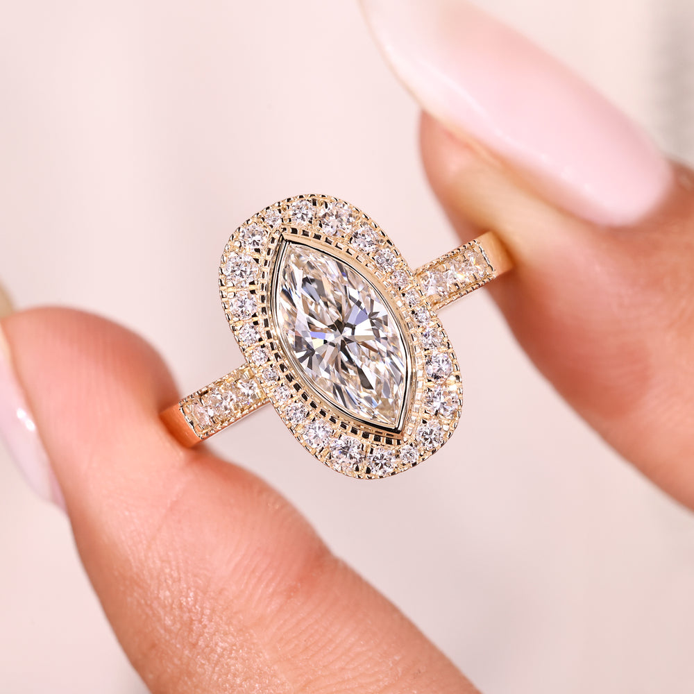 Milgrain marquise diamond ring with round accents.
