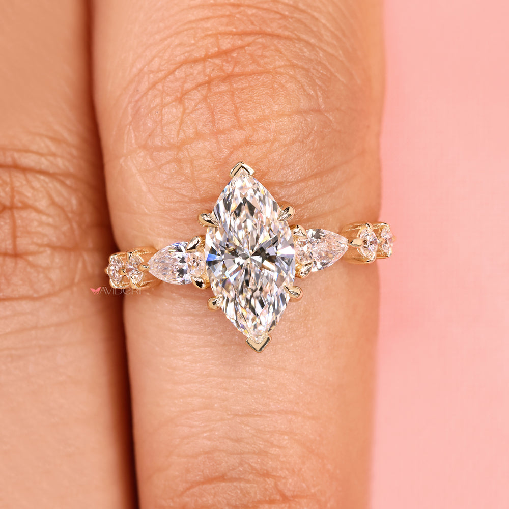 Marquise ring with round and pear side stones.

