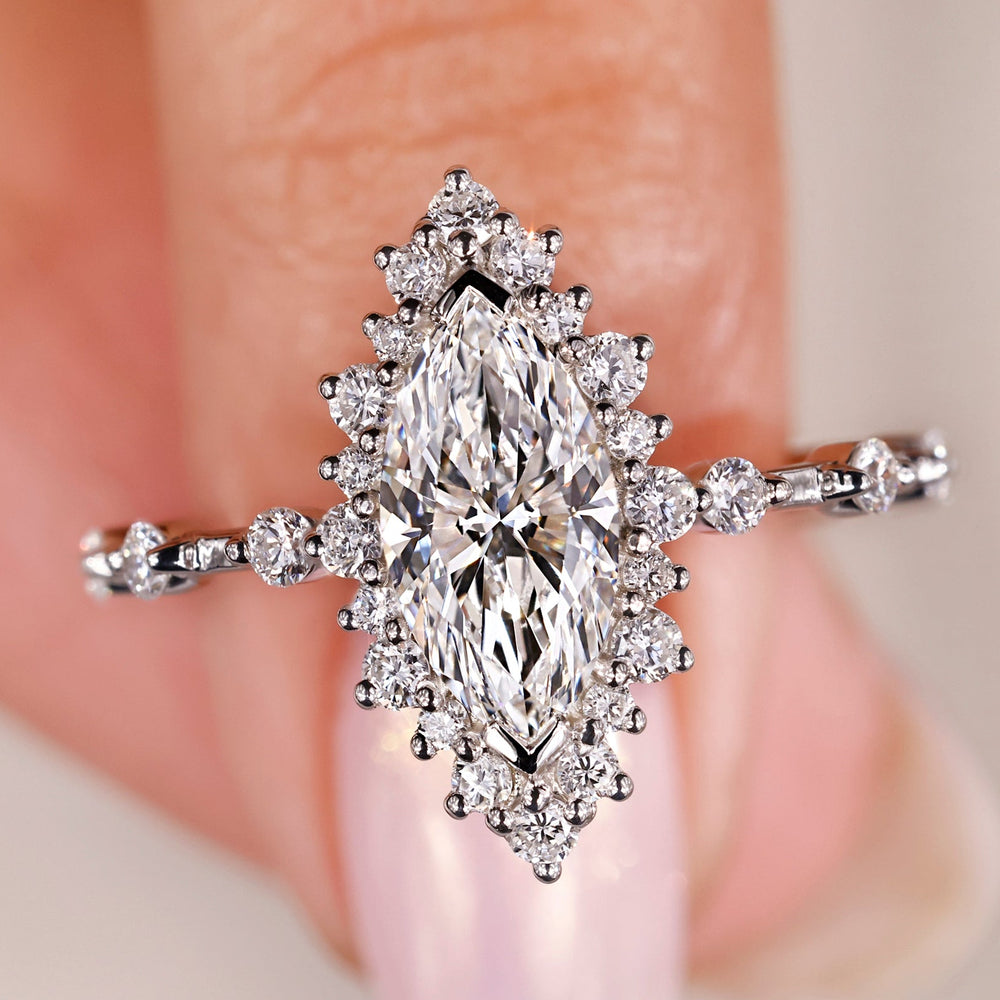 marquise diamond engagement ring with round diamond accents in white gold.