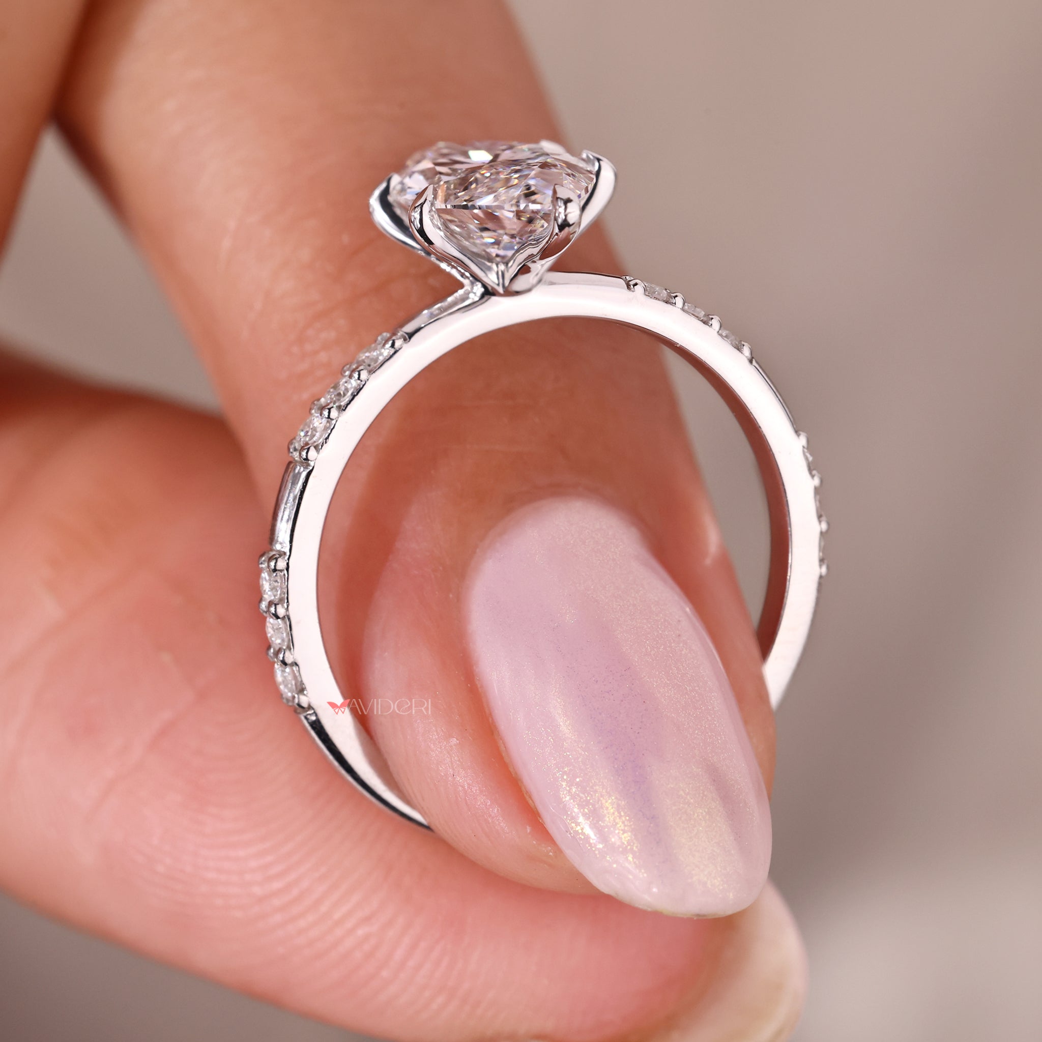 white gold engagement ring with six claw prong setting and pave band.