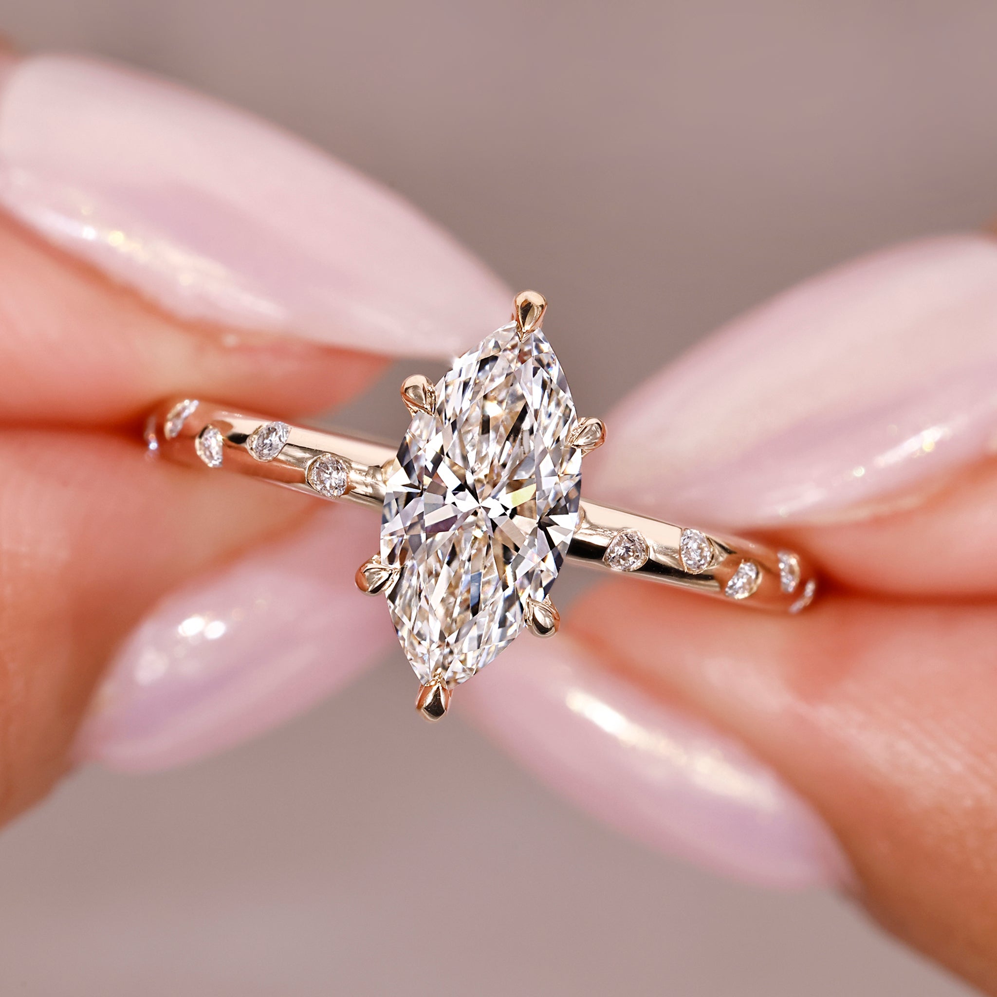 marquise diamond engagement ring with round diamonds in custom yellow gold setting.