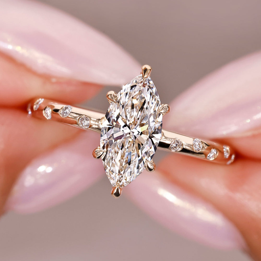 marquise diamond engagement ring with round diamonds in custom yellow gold setting.