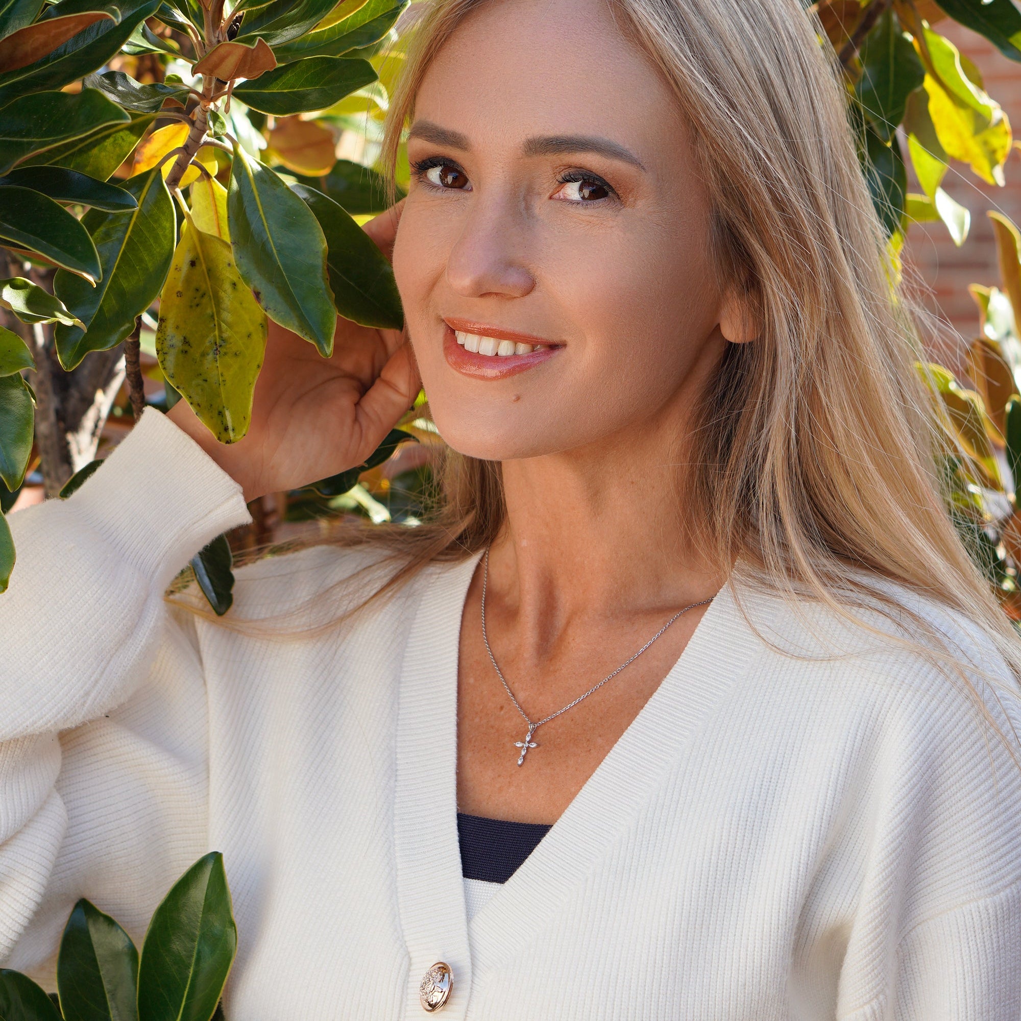 Side view of model wearing cross pendant necklace.