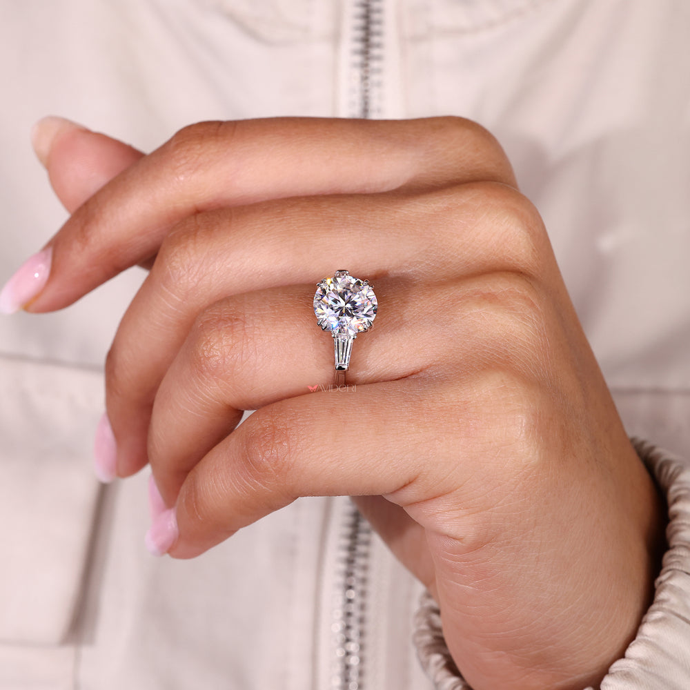 Round moissanite engagement ring with double claw prongs.
