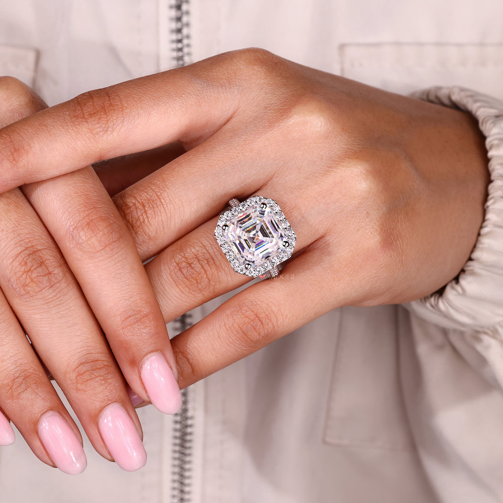 Asscher cut moissanite halo ring with round stones.