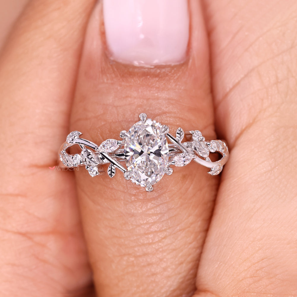 Oval cut diamond ring with six leaf prong and nature inspired design.
