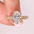 Oval diamond ring with marquise round side stones.
