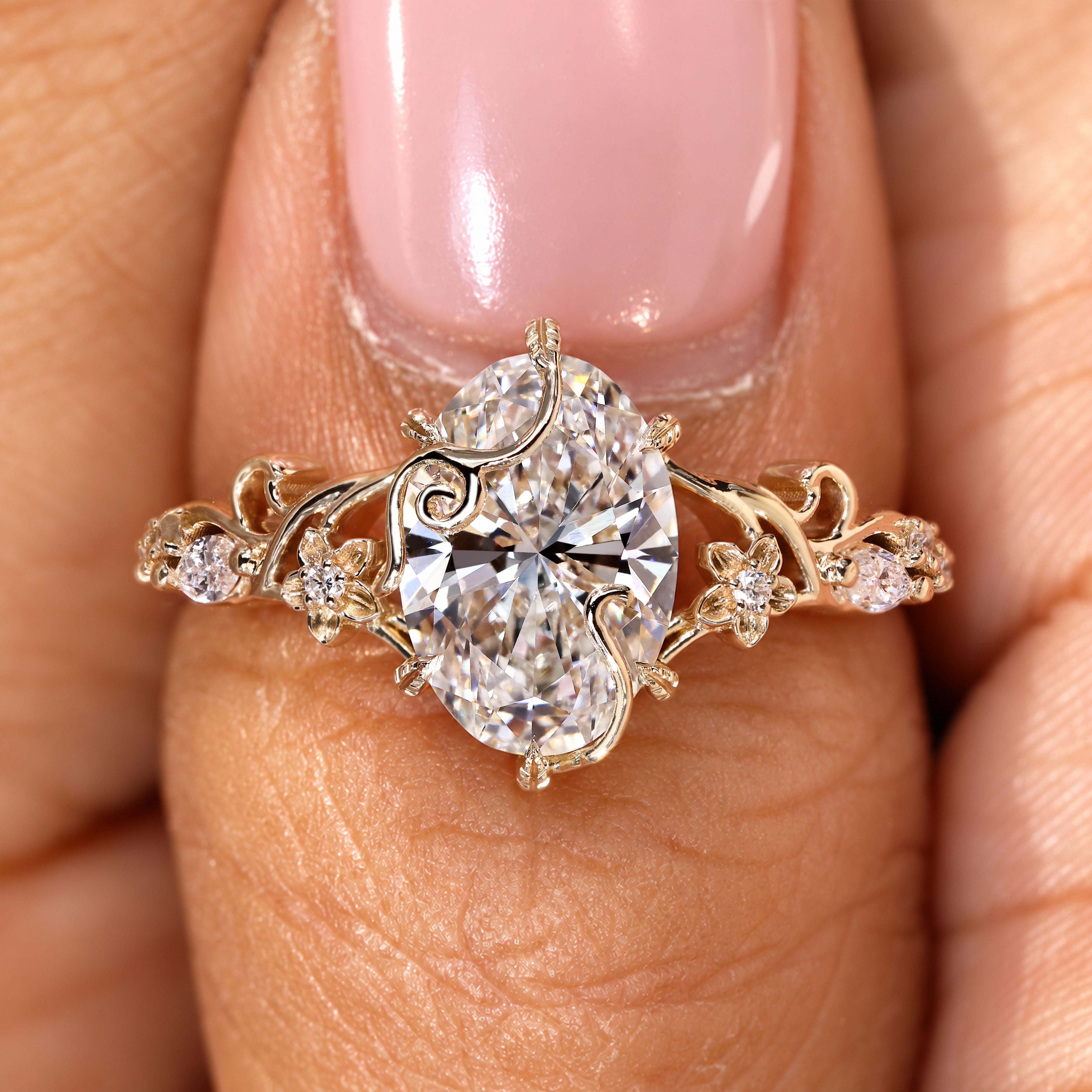 Handmade oval diamond ring with floral vine details.
