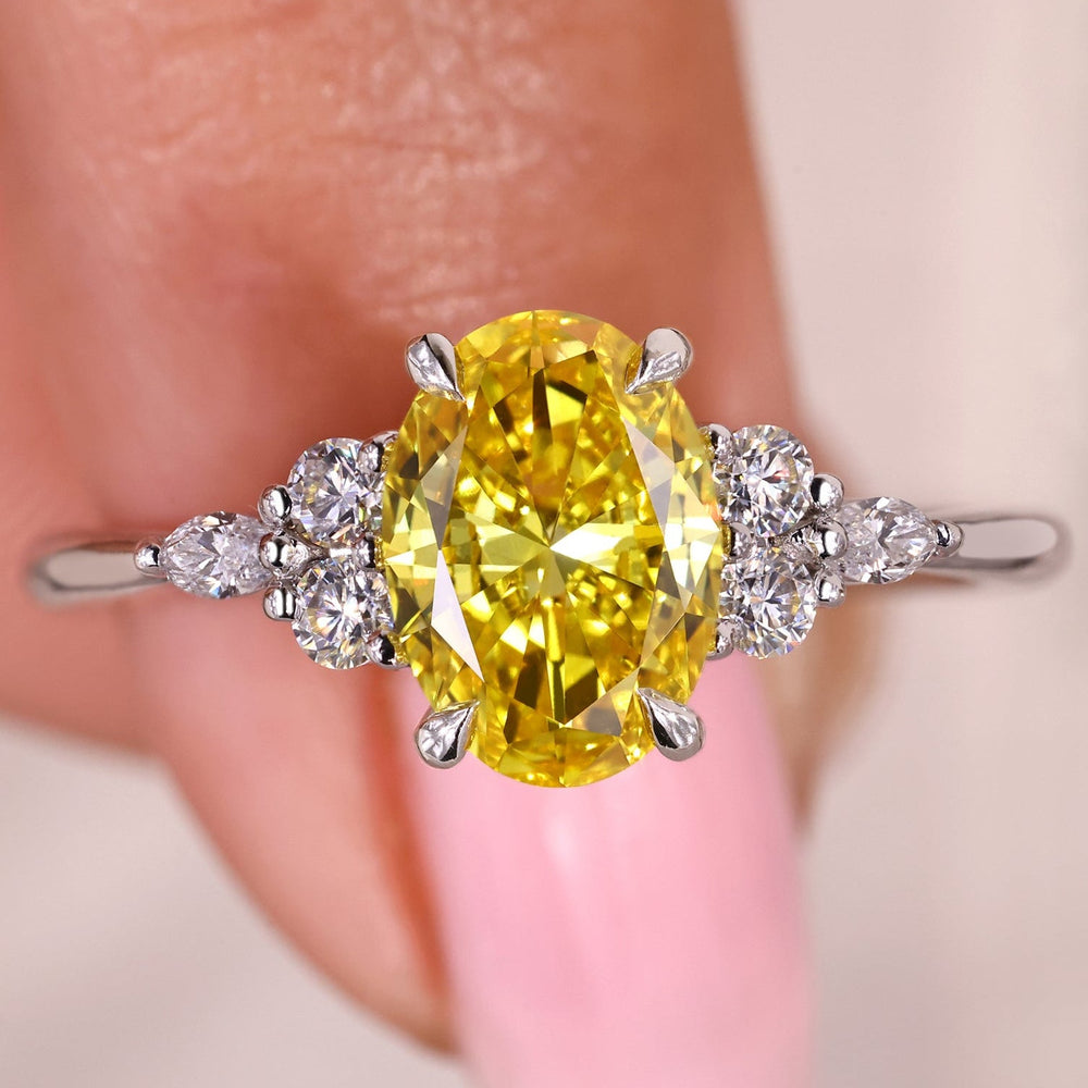 Oval cut yellow diamond ring with marquise and round side stones.