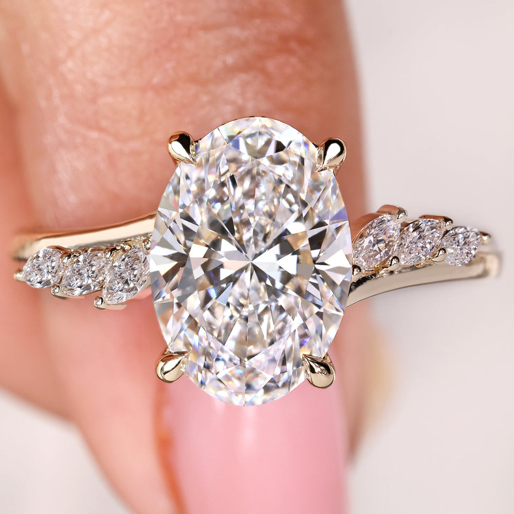 Oval cut diamond ring with marquise and round side stones
