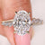Oval cut diamond ring with marquise and round side stones
