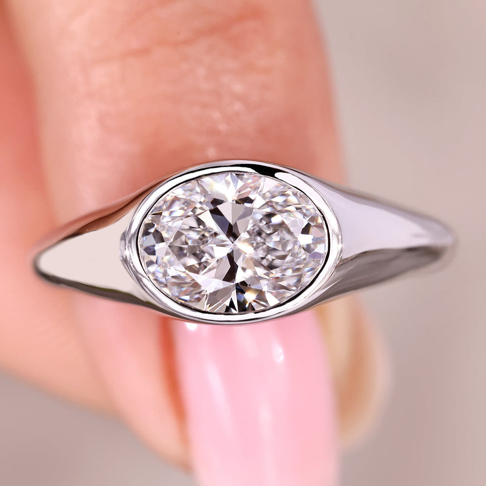 Oval cut diamond ring with bezel east to west setting.
