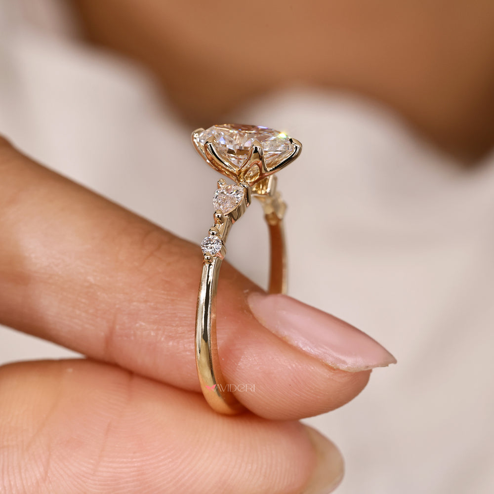 Oval ring with pear and round side stones design.

