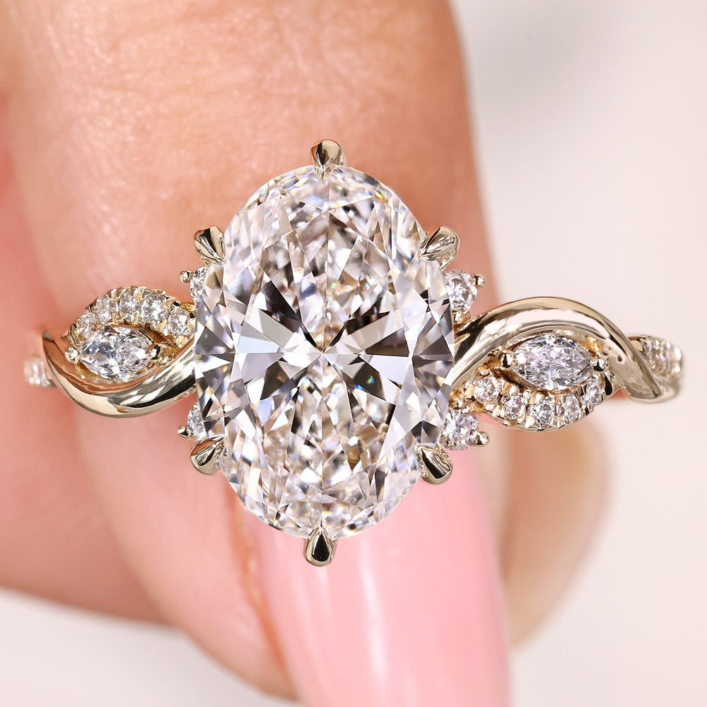 Oval cut engagement ring with marquise side stones and pavé
