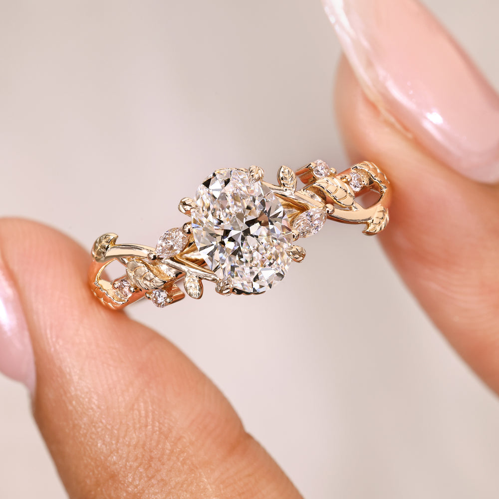 Oval ring with four leaf prongs and side stones.
