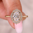 Oval diamond engagement ring with round halo setting.