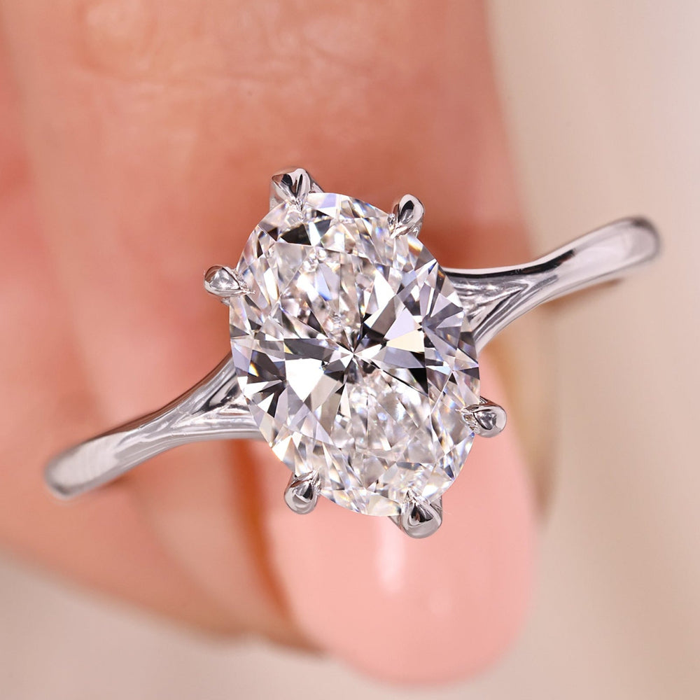 Solitaire oval diamond engagement ring with six claw prong in white gold.