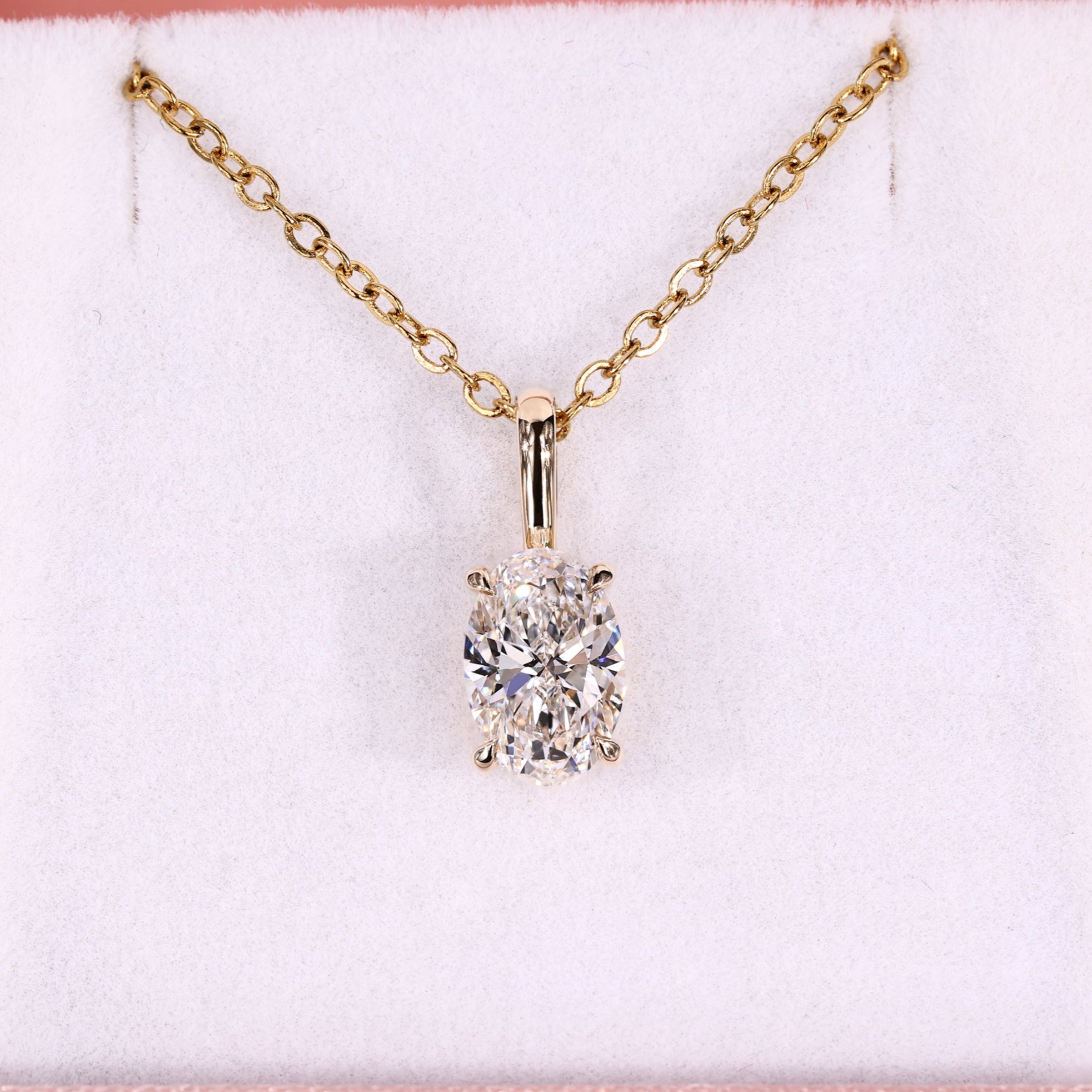 Oval solitaire pendant with 4 claw prong setting in yellow gold.