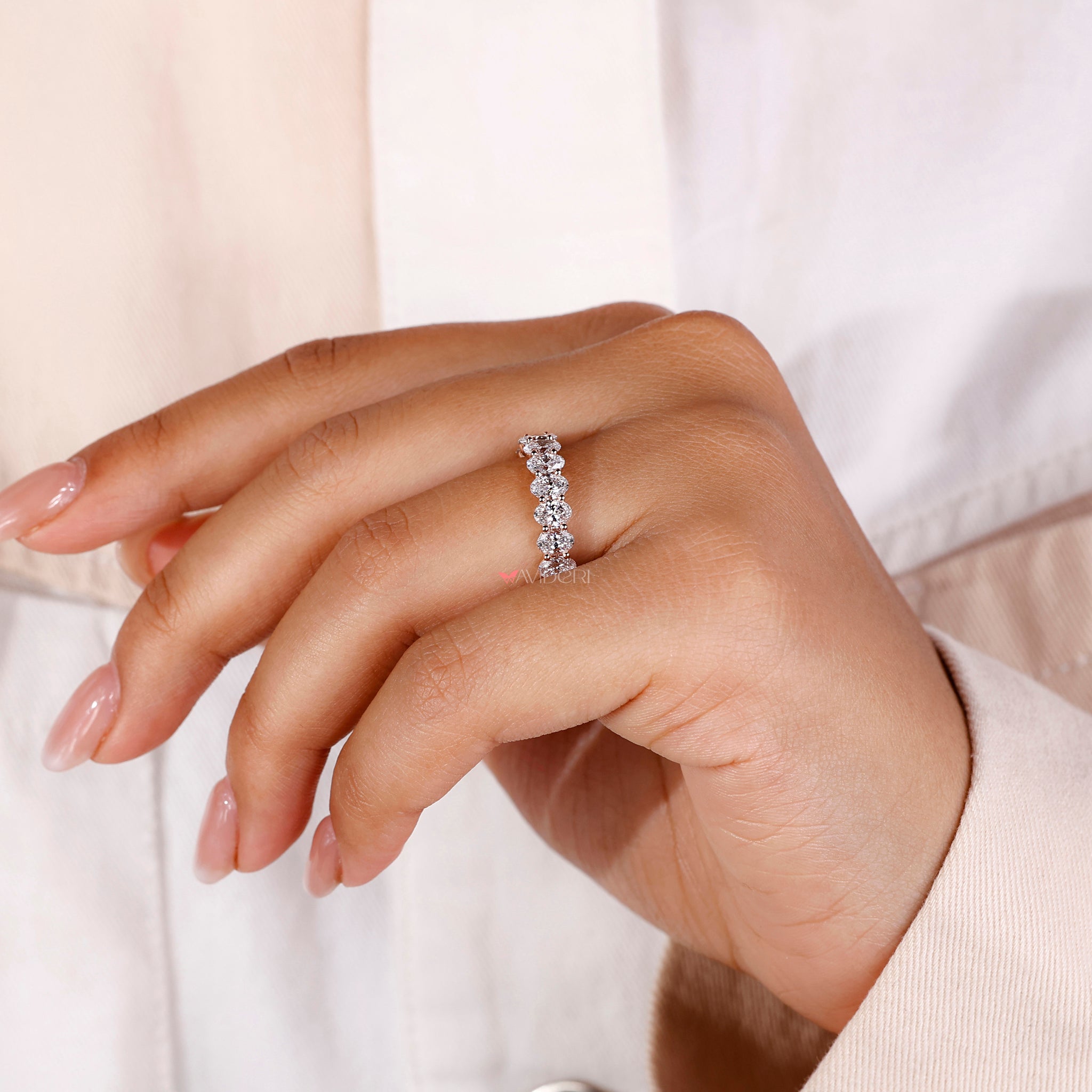 Timeless oval eternity ring with shared prong diamond band for a sophisticated wedding set.
