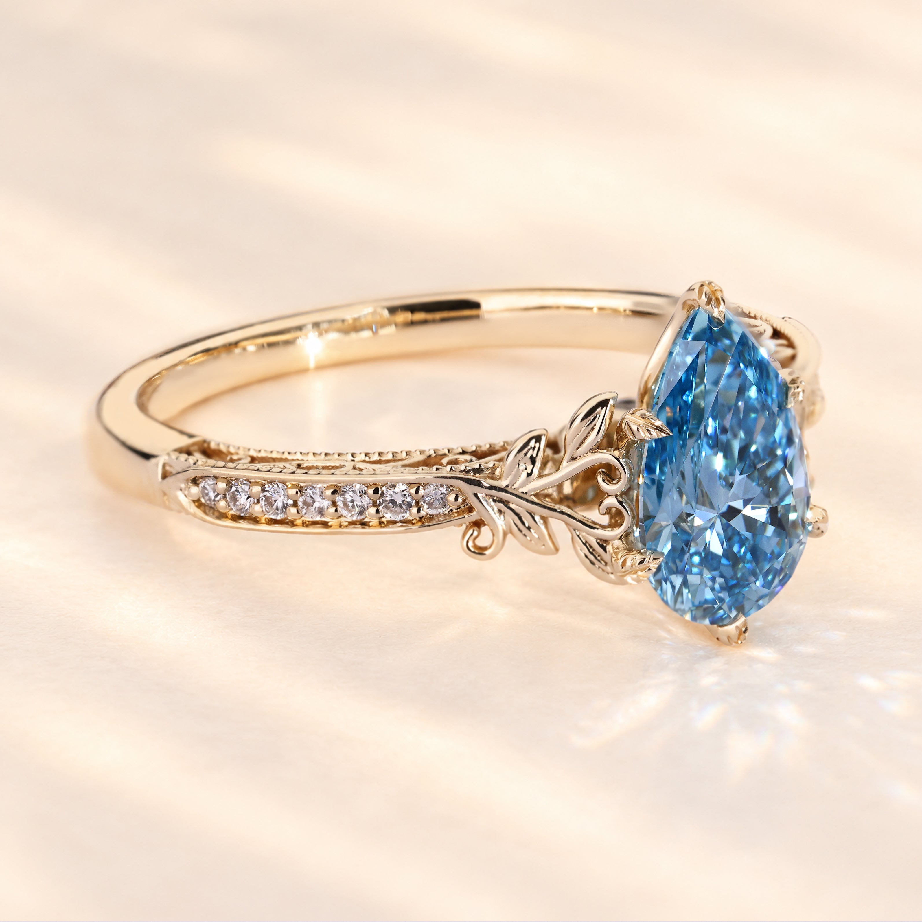 Pear cut blue diamond ring with vintage filigree detail.
