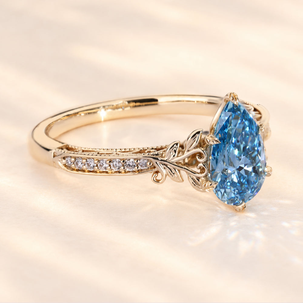 Pear cut blue diamond ring with vintage filigree detail.
