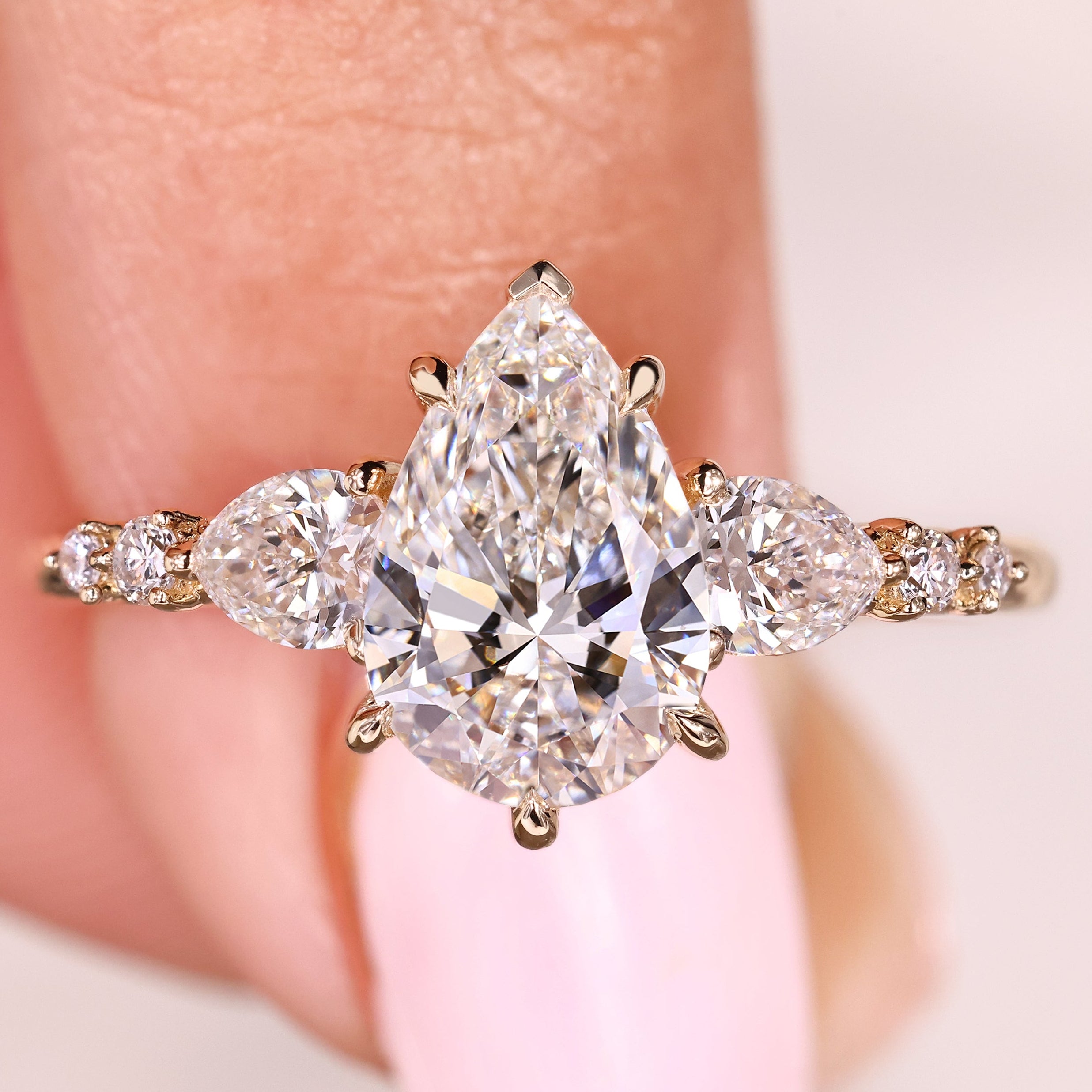 Pear cut diamond ring with pear and round side stones
