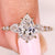 Pear cut diamond ring with pear and round side stones
