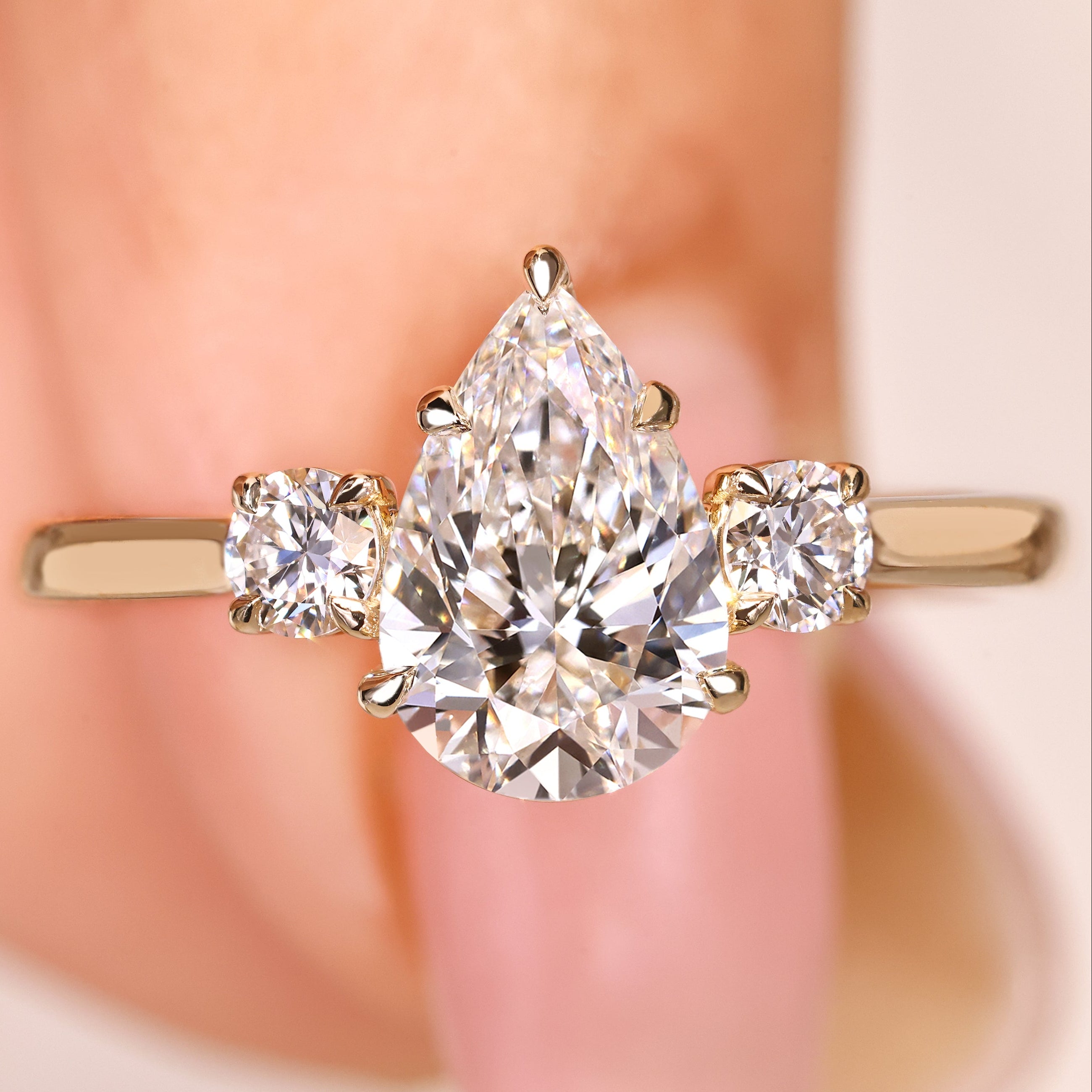 Pear cut lab grown diamond ring with round side stones
