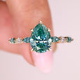 Pear cut moissanite ring cyan blue stone style.
