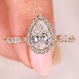 Pear diamond ring with halo and pave band.
