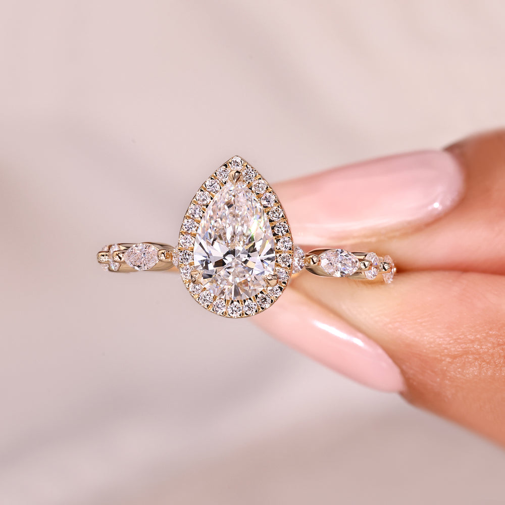 Pear diamond ring with round halo stones.

