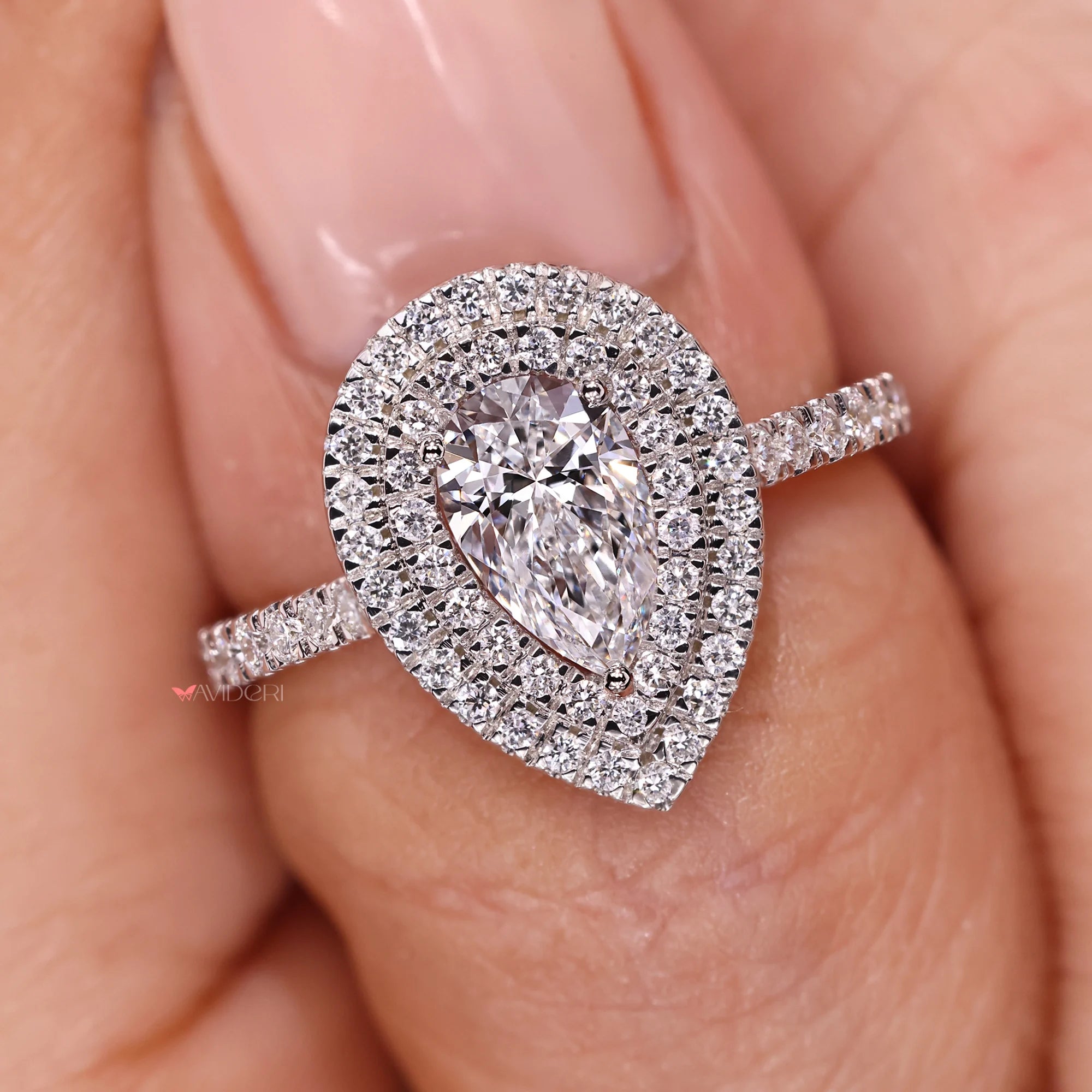 Round prong design highlighting a pear shaped engagement ring.