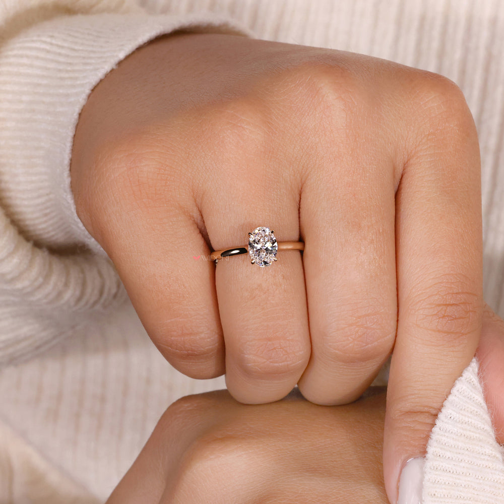 An Image of a hand wearing a solitaire oval-cut engagement ring.
